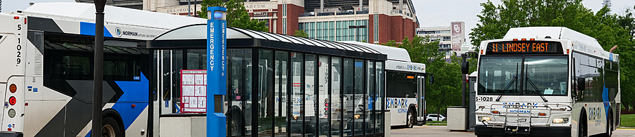 Banner of EMBARK Norman bus at Brooks Station in front of Oklahoma University.