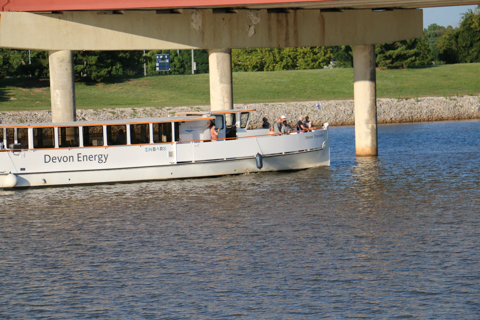 People riding on the Oklahoma River Cruiser while it drives under the I-40 bridge on the Oklahoma River.