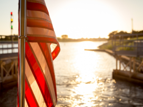 Sunshine bounces off the Oklahoma River and shines on a United States of America flag on a River Cruiser.