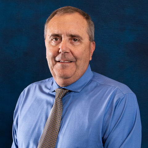 Headshot of Facility and Fleet Manager Dennis Fry on blue background.