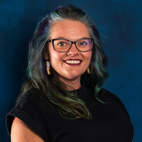 Headshot of Purchasing Specialist Whitney Broesel on blue background.